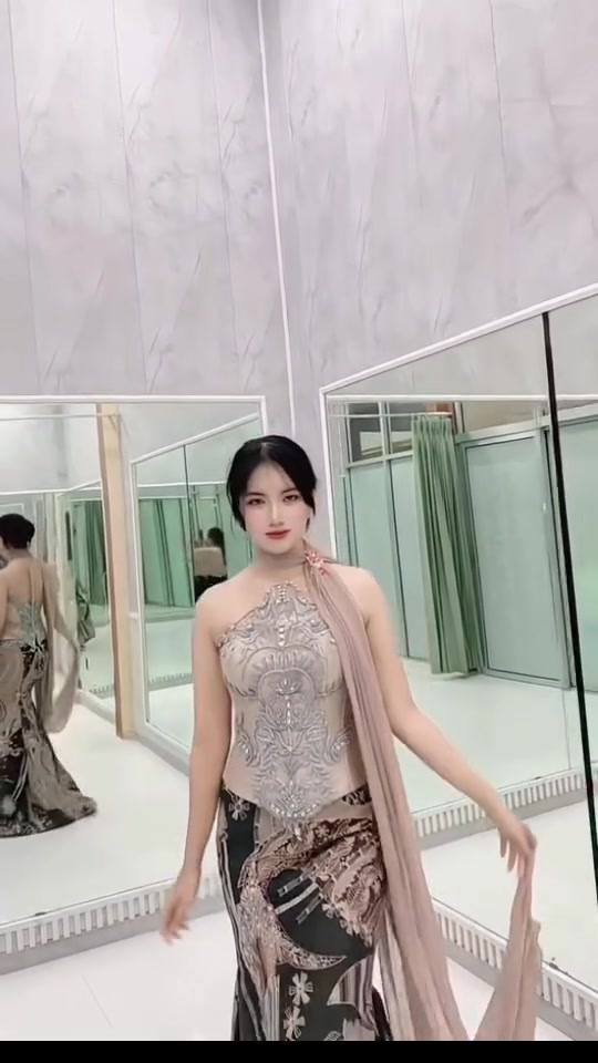 Kebaya warna sampanye sedang dicoba di depan cermin butik