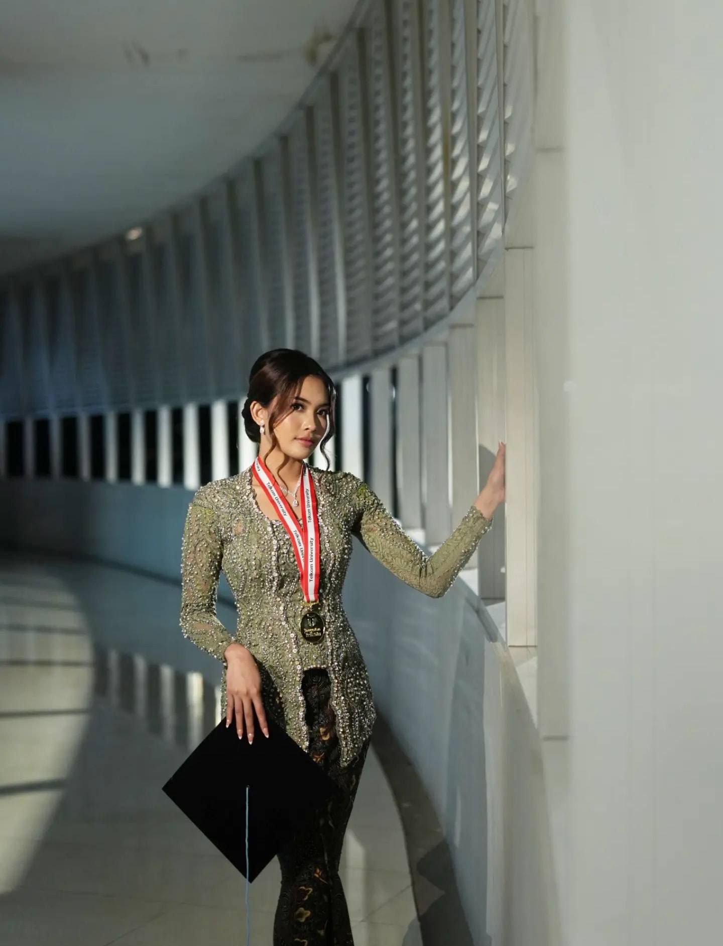Kebaya brokat berpayet warna sage dengan kain batik, dipakai saat wisuda